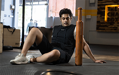 Man using Hanubal wooden Mudgar for home workout in a compact training space